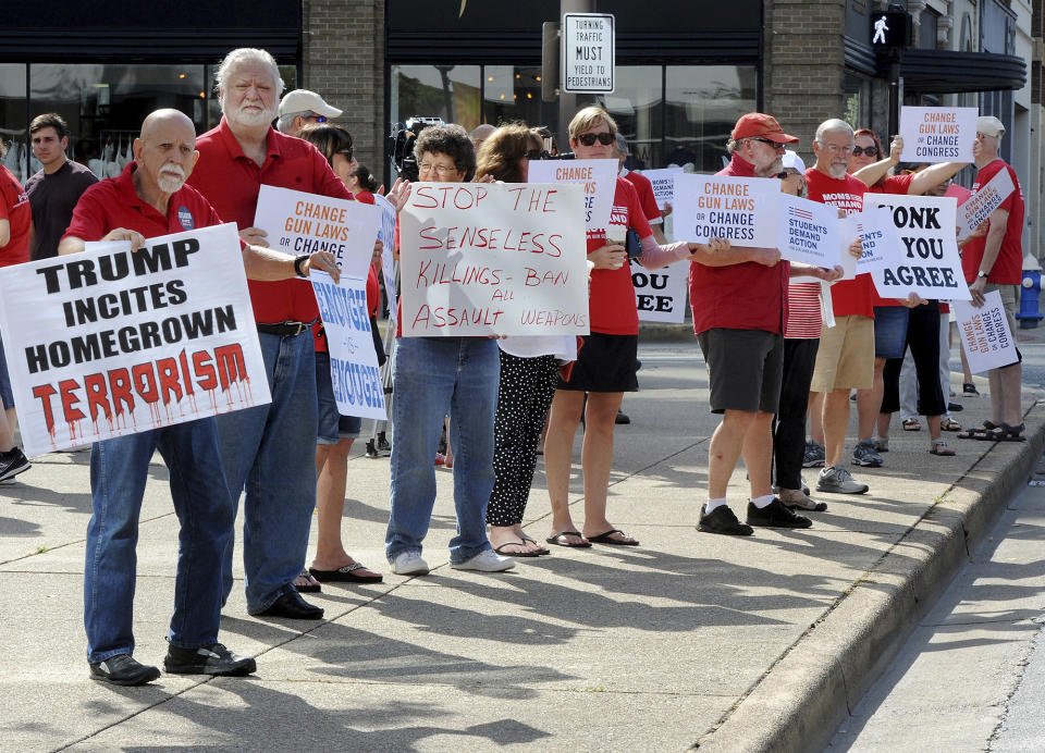 People hold signs protesting gun violence during a rally in front of the United Building in Charleston, W.V., Saturday, Aug. 17, 2019. (Chris Dorst/Charleston Gazette-Mail via AP)