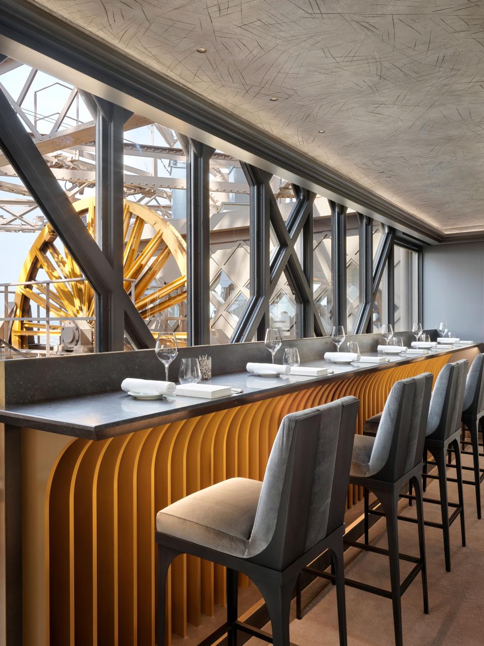 A newly installed bar offers diners a front-row seat to view the tower's mechanical wheels and the City of Light beyond.
