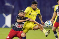 New England Revolution midfielder Lee Nguyen, left, and Nashville SC midfielder Anibal Godoy fight for the ball during the first half of an MLS soccer match Friday, Oct. 23, 2020, in Nashville, Tenn. (AP Photo/Mark Humphrey)