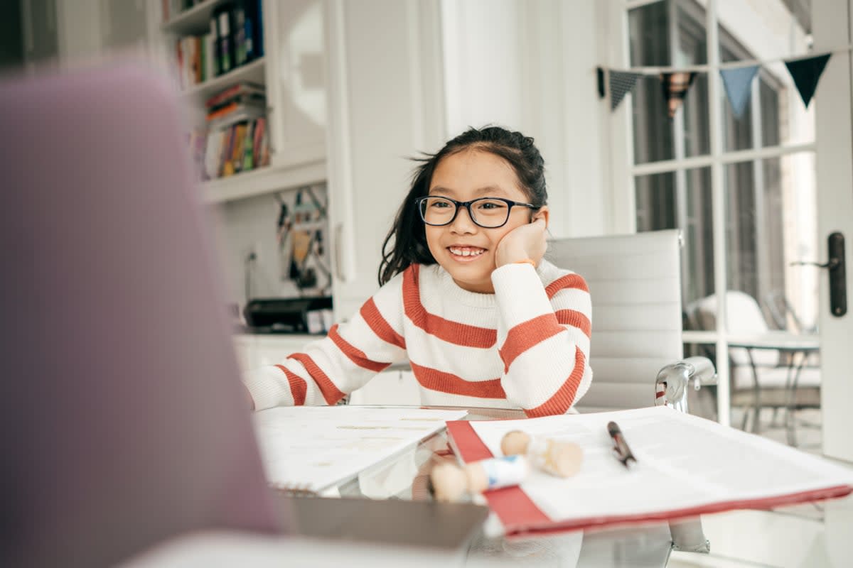 A young girl is tutored online. 