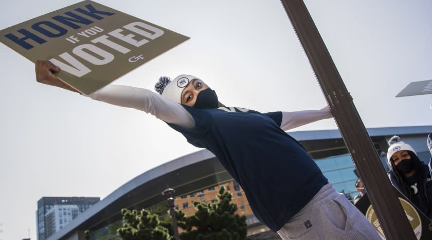 Eylia Love, of the Georgia Tech Womens basketball team, holds a voting sign outside of McCamish Pavillion.