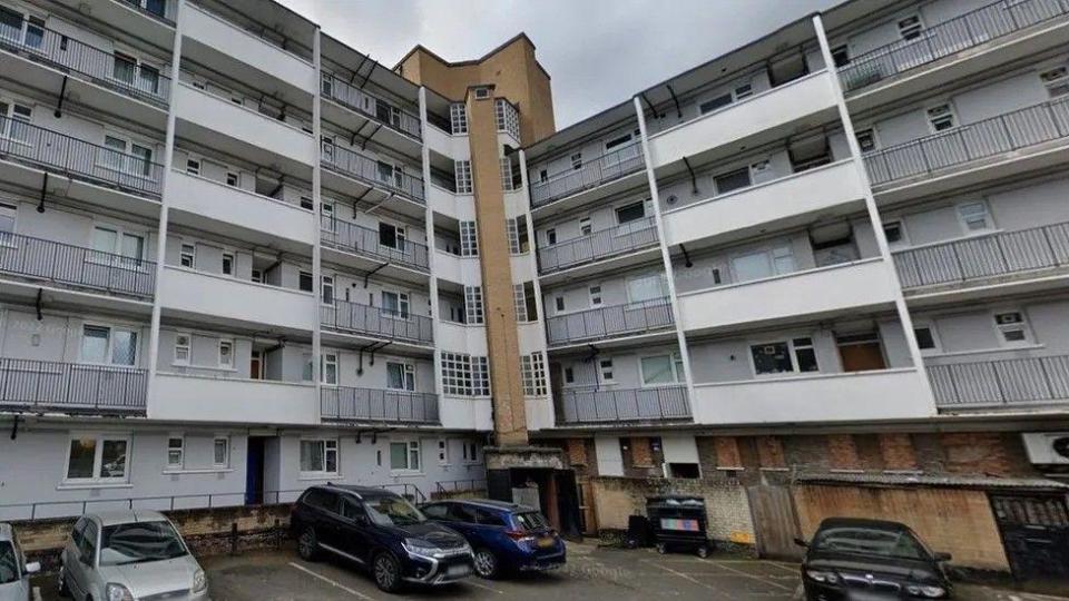 The block of flats in Bermondsey where Kacey Clarke was fatally stabbed. The photo shows the car park area and the white flats with black railings across the balconies.