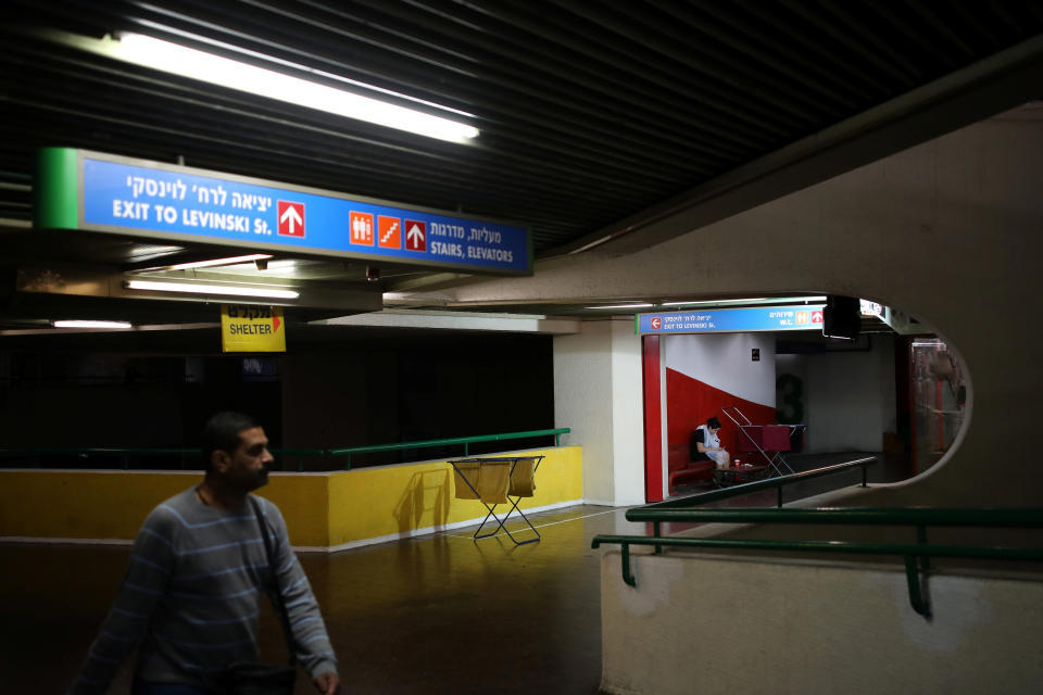 A man walks by as a woman waits outside a hair salon at the Central Bus Station on Jan. 11. (Photo: Corinna Kern/Reuters)