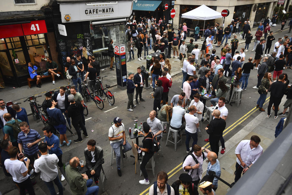 Drinkers in Soho congregate, as coronavirus lockdown restrictions eased across the country, in London, Saturday July 4, 2020. England embarked on perhaps its biggest lockdown easing yet as pubs and restaurants reopened for the first time in more than three months. (Victoria Jones/PA via AP)