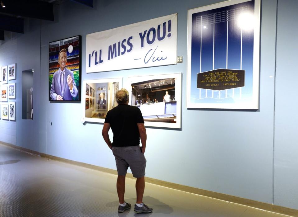 Los Angeles, CA - August 05: A fan looks at memorabilia of Vin Scully as the Los Angeles Dodgers celebrate the life of Hall of Fame broadcaster Vin Scully who passed away Tuesday night at the age of 94 prior to a MLB baseball game between the Los Angeles Dodgers and the San Diego Padres at Dodger Stadium in Los Angeles on Friday, August 5, 2022. (Photo by Keith Birmingham/MediaNews Group/Pasadena Star-News via Getty Images)