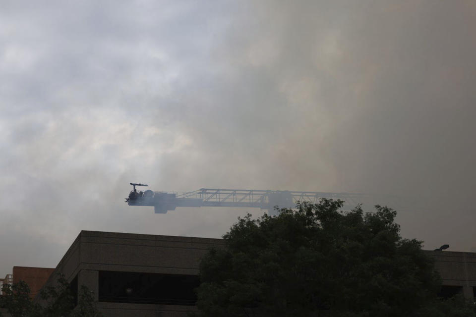 Firefighters work the scene of a massive fire spread across at least two structures and threatened others in Charlotte's South Park neighborhood, North Carolina, Thursday morning, May 18, 2023. (Khadejh Nikouyeh/The Charlotte Observer via AP)