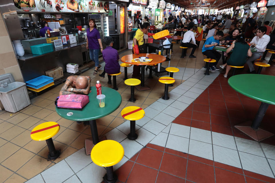 Chairs are marked with red tape at a hawker centre in Singapore as authorities implement social distancing measures to combat the coronavirus on 19 March, 2020. in Singapore. (PHOTO: Getty Images)