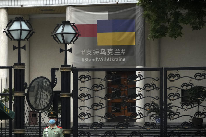 A paramilitary policeman stands watch at the Poland Embassy displaying a banner support for Ukraine, in Beijing, Thursday, May 17, 2023. Embassies in Beijing have been asked by the Chinese government to avoid displaying propaganda after some raised Ukrainian flags or set up placards declaring support for Ukraine. (AP Photo/Andy Wong)