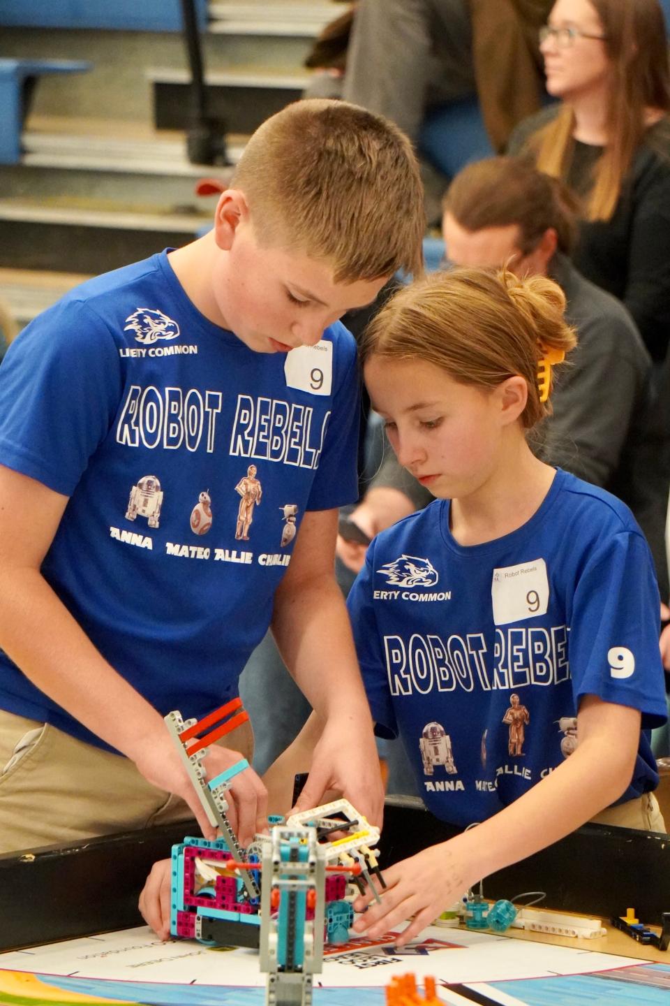 Robot Rebels team members Charlie Notarfrancesco and Alli Smith work on their robot during a First Lego League competition at Poudre High School. The Robot Rebels, a team of sixth-graders from Liberty Common School, have been selected to compete in an international competition next month in Morocco.