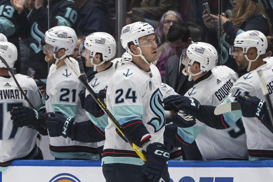 Seattle Kraken's Jamie Oleksiak (24) celebrates with his teammates after his goal against the Vancouver Canucks during the second period of an NHL hockey game Saturday, Nov. 18, 2023, in Vancouver, British Columbia. (Ethan Cairns/The Canadian Press via AP)