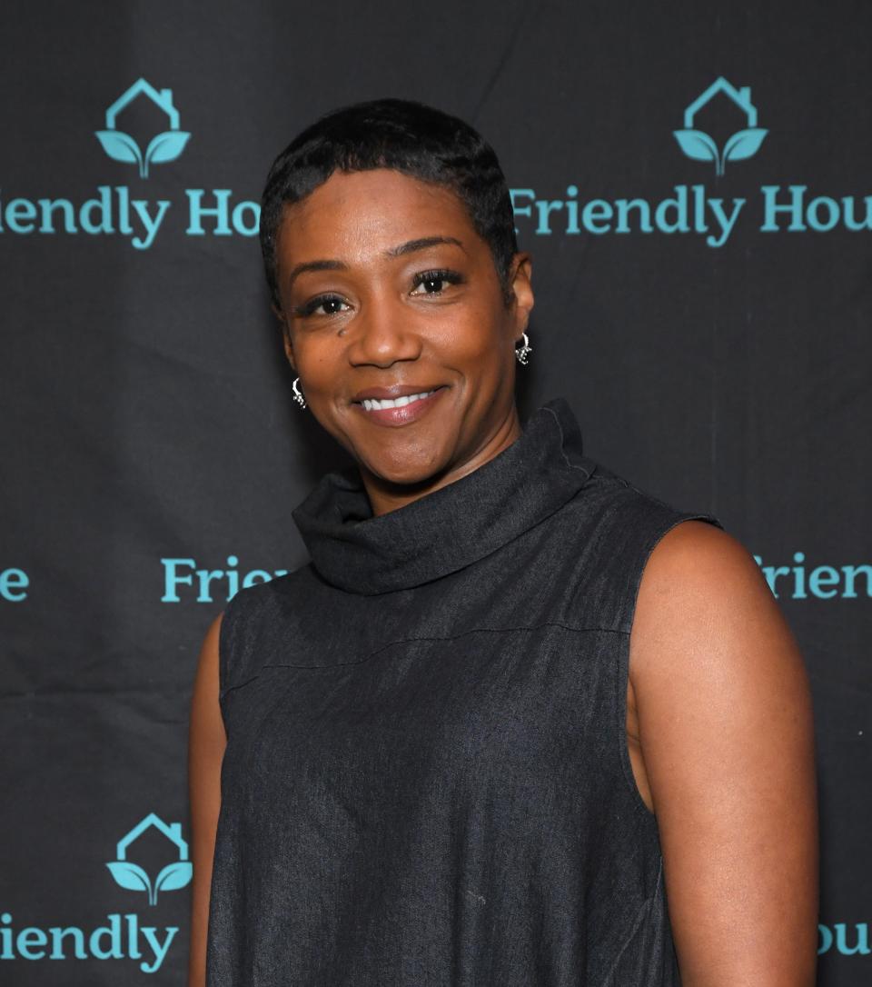 Tiffany Haddish in a black sleeveless cowl neck dress at a Friendly House event