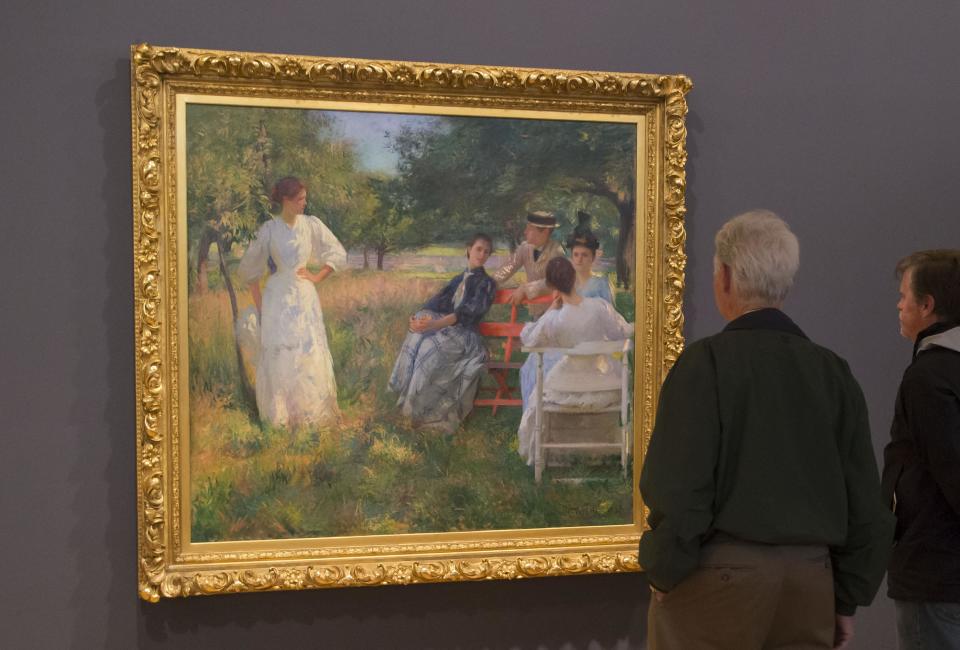 People look at the painting of American painter Edmund Tarbell, 1862-1938, in the Orchard, 1891, during the exhibition, "American Impressionism: A New Vision", at the Impressionist museum in Giverny, 70 kms (45 mls) north west of Paris, on Friday, March 28, 2014. A new exhibit at Normandy’s Impressionism Museum tells for the first time the little-known story of American Impressionism from where it all began _ at the picturesque water lily-filled Giverny gardens of Claude Monet that Americans colonized for three decades. (AP Photo/Michel Euler)