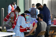 Health care workers receive a COVID-19 vaccination at Ritchie Valens Recreation Center, Wednesday, Jan. 13, 2021, in Pacoima, Calif. (AP Photo/Marcio Jose Sanchez)