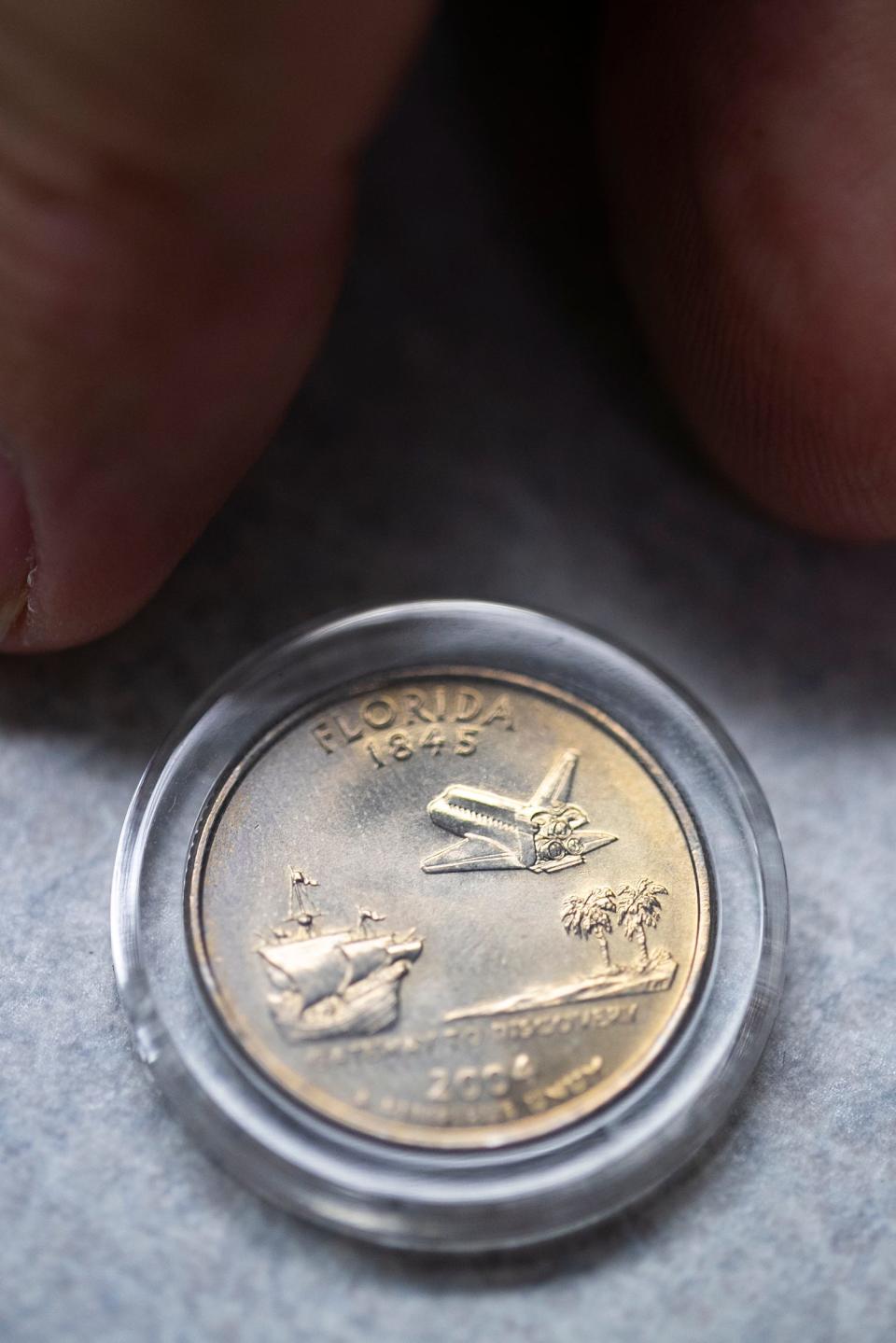 Gary E. Lewis displays a 2004 Florida state quarter. He was the chairman of the Florida State Quarter committee in charge of the selection process.