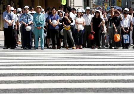 People wearing and holding helmets take part in a drill simulating a 7.2 magnitude earthquake in Tokyo, Japan, August 26, 2016. REUTERS/Kim Kyung-Hoon