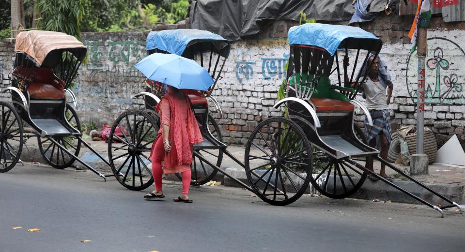 Indian rikshaw pullers wait during a hot afternoon in Kolkata, eastern India, 19 April 2022 (EPA)