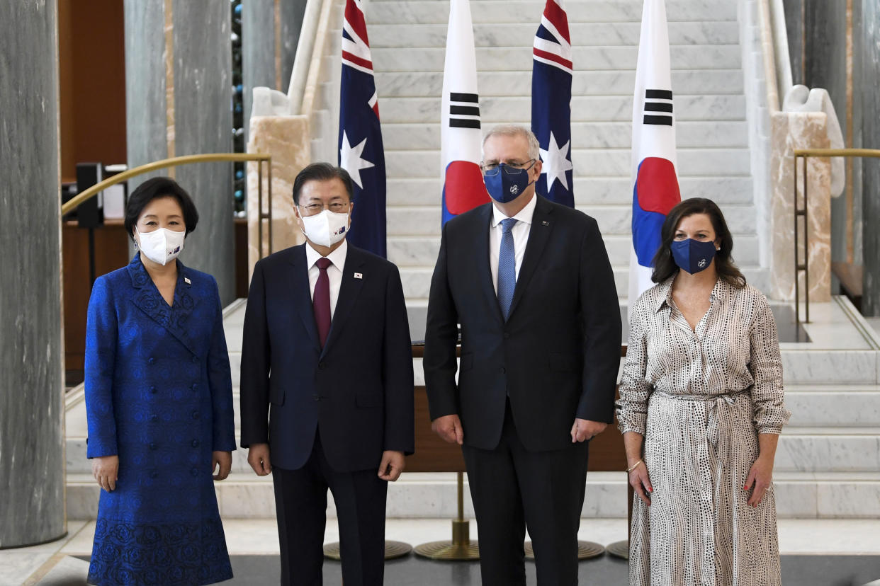 South Korean President Moon Jae-in, second left, and his wife, Kim Jung-sook, left, pose for a photo with Australian Prime Minister Scott Morrison and his wife, Jenny, right, at Parliament House, in Canberra, Australia, Monday, Dec. 13, 2021. Moon is on a two-day official visit to Australia. (Lukas Coch/Pool Photo via AP)