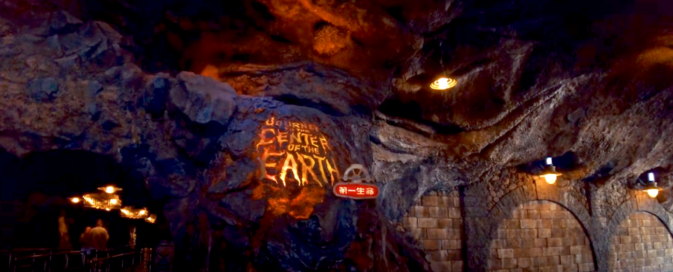 Cavern-themed entrance to a ride at Tokyo DisneySea labeled "Journey to the Center of the Earth" with an illuminated red sign