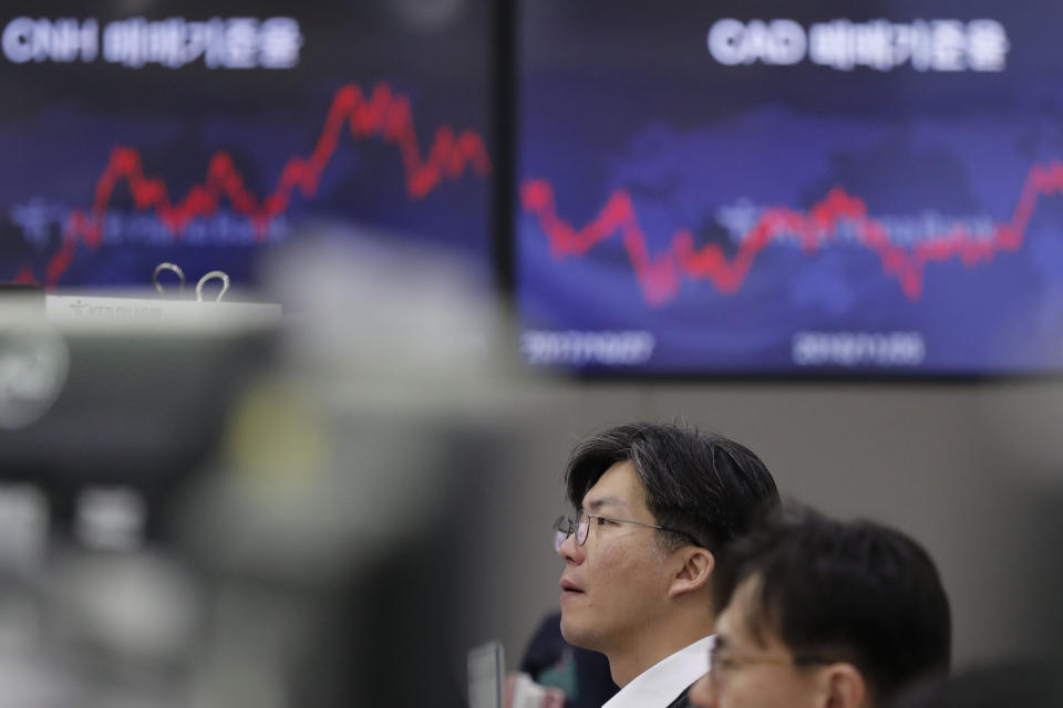 A currency trader watches computer monitors near the screens at the foreign exchange dealing room in Seoul, South Korea, Friday, Nov. 8, 2019. Asian stock markets were mixed Friday amid uncertainty about a possible U.S.-Chinese agreement to roll back tariffs in their trade war. (AP Photo/Lee Jin-man)