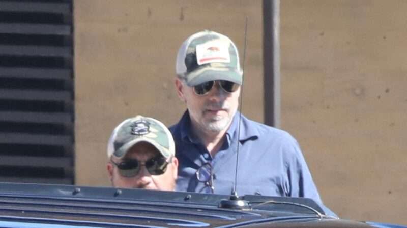 Hunter Biden walks to a car while wearing a baseball cap