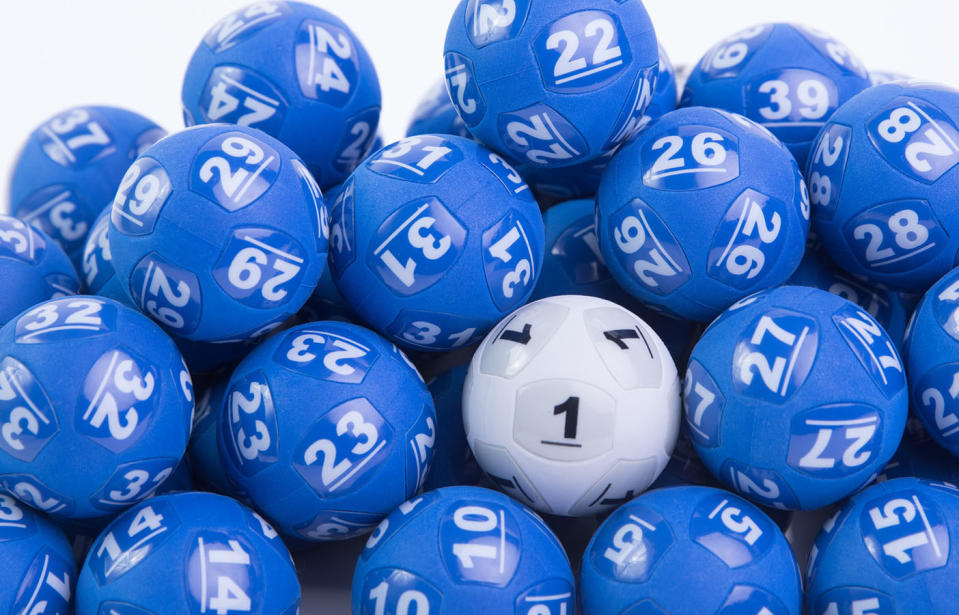 Pictured are blue Powerball lotto balls with one white ball among them. 