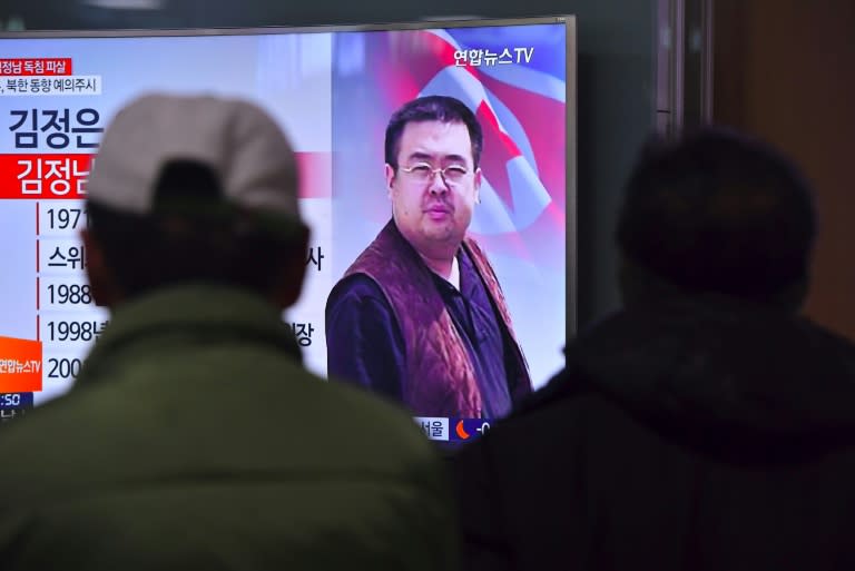 People in a Seoul railway station watch a TV news report on the death of Kim Jong-Nam