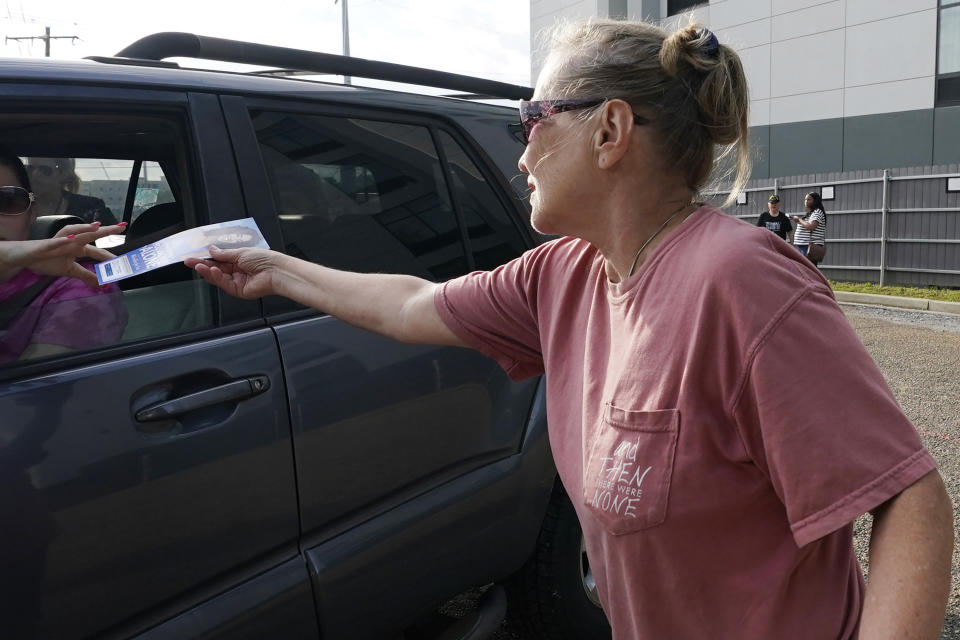 Longtime anti-abortion activist Barbara Beavers, hands out pro-life materials to an incoming patient outside the Jackson Women's Health Organization (JWHO), Mississippi's last remaining abortion clinic, called the "Pinkhouse", Tuesday, May 3, 2022. (AP Photo/Rogelio V. Solis)