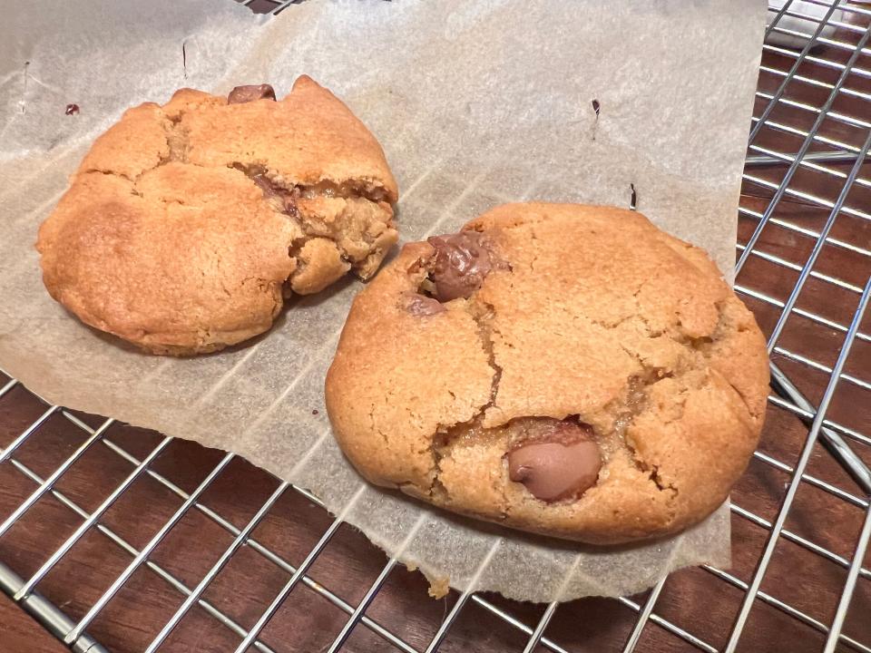 two air-fried chocolate chip cookies cooling on a wire rack