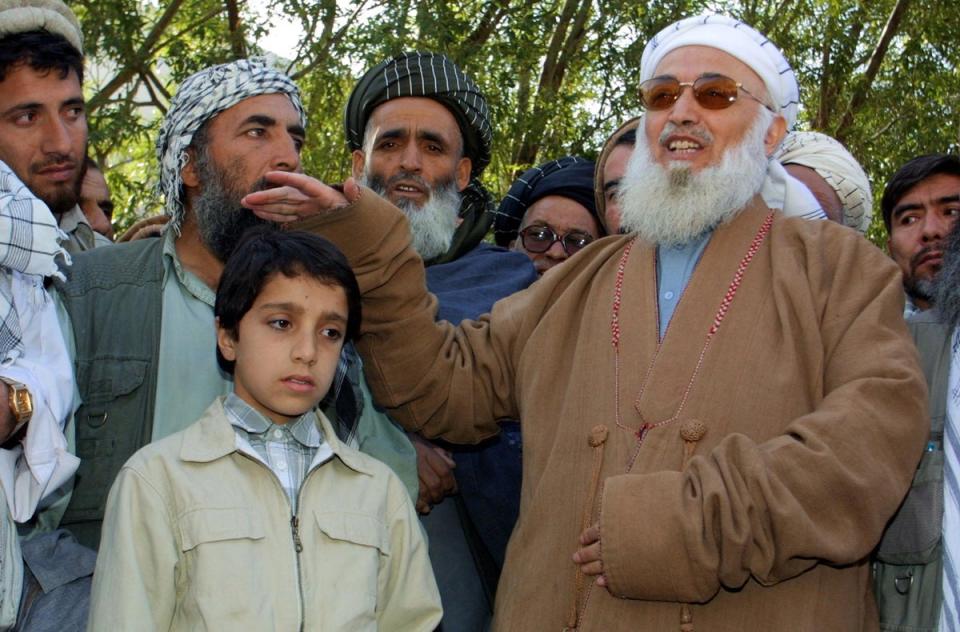 A 12-year-old Ahmad Massoud, the son of dead commander Ahmad Shah Massoud, being comforted by the then Afghan president at a funeral ceremony after his father’s death in an al-Qaeda attack (AFP via Getty)