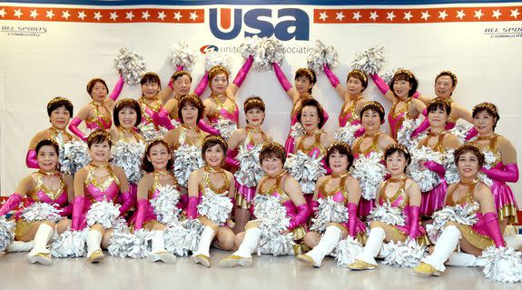 In this picture taken on March 26, 2016, members of the middle-aged and elderly women cheerleading group "Japan Pom Pom" pose for photographs during the national cheerleading and dance championship 2016 of the United Spirit Association (USA) Japan in Chiba, a suburb of Tokyo. Strutting her stuff in a gold-hemmed mini-skirt, white leather boots and shaking silver pom-poms, octogenarian Fumie Takino has discovered her elixir of youth -- cheerleading. Takino and her troupe of spirited grannies tweak the nose of old age, even if their rambunctious routine to the song "Dreamgirls" leaves them painfully out of breath and their pink tank tops dripping with sweat. / AFP / TORU YAMANAKA / TO GO WITH AFP STORY: "JAPAN-ELDERLY-CHEERLEADING" FEATURE by Harumi OZAWA (Photo credit should read TORU YAMANAKA/AFP/Getty Images)