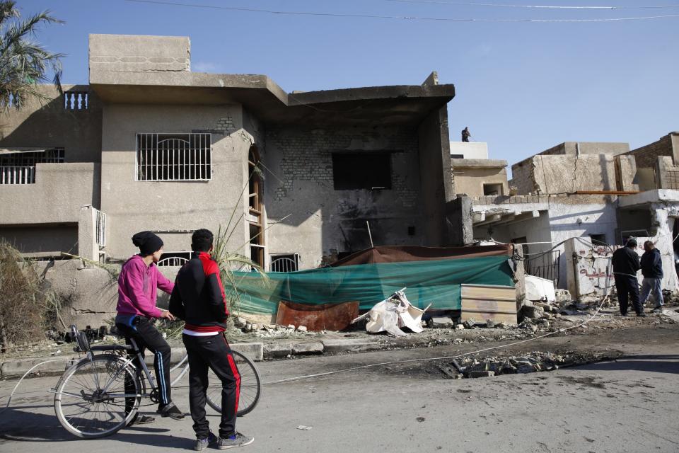 Civilians gather at the site of a car bomb attack in the Risala district in Baghdad December 15 2013. At least 17 people, most of them Shi'ite Muslims, were killed in a wave of bombings and shootings across Iraq on Saturday ahead of a major Shi'ite ritual, medical and police sources said. The deadliest of the attacks took place in Baghdad's mainly Shi'ite district of Risala when a car bomb blew up near a gathering of Shi'ite pilgrims, killing seven people and wounding another 16, police and medics said. (REUTERS/Thaier Al-Sudani)