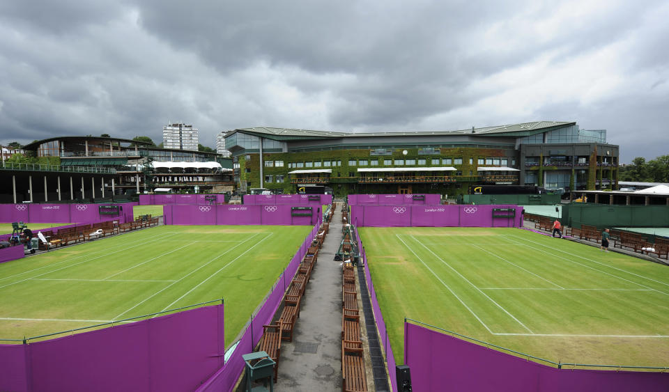 Outside courts are surrounded with Olympic hoarding at the All England Lawn Tennis Club (AELTC) as preparations are made for the London 2012 Olympic Games, in London July 9, 2012. REUTERS/Ki Price (BRITAIN - Tags: SPORT OLYMPICS TENNIS)