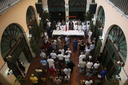 Followers of the Yoruba religion stand for the Cuban National Anthem before delivering the recommendations based on their annual predictions for the New Year during a news conference in Havana, Cuba, January 3, 2017. REUTERS/Alexandre Meneghini