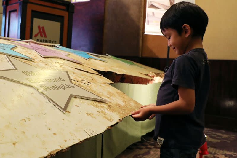 Muhammad, son of Mohd Hazrin Hasnan, the flight attendant who was onboard the missing Malaysia Airlines flight MH370, touches a debris during its sixth annual remembrance event in Putrajaya