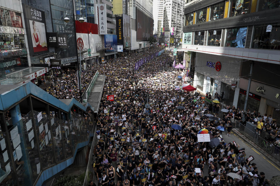Protesters take part in a march on a street in Hong Kong, Sunday, July 21, 2019. Thousands of Hong Kong protesters marched from a public park to call for an independent investigation into police tactics. (AP Photo/Vincent Yu)