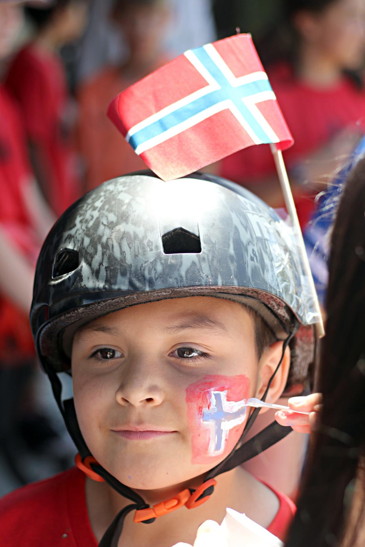 10-year-old Johnny Lepe, of the Poulsbo Elementary School Unicycle Team, gets a Norway flag painted on his face prior to the start if the 55th annual Poulsbo Viking Fest parade on Saturday, May 20, 2023.