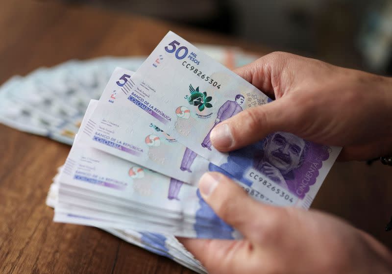 FOTO DE ARCHIVO. Un empleado cuenta billetes de pesos colombianos en una casa de cambio en Bogotá