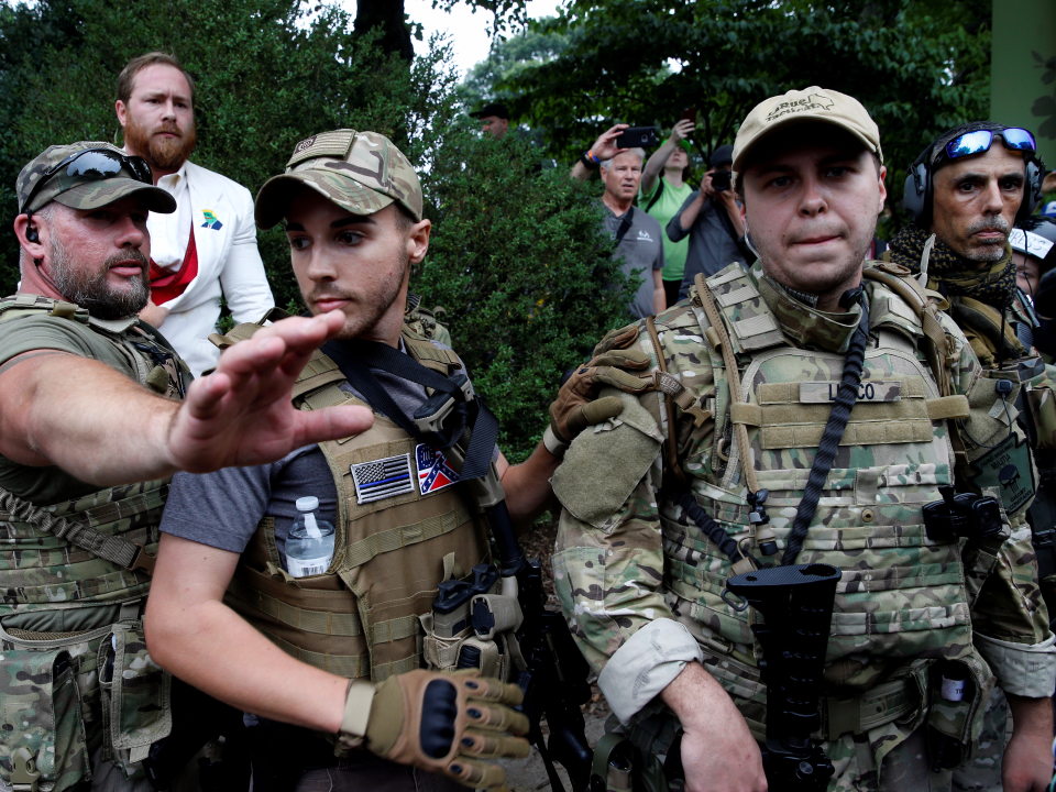 A white supremacists stands behind militia members after he scuffled with a counter demonstrator in Charlottesville, Virginia, U.S., August 12, 2017.