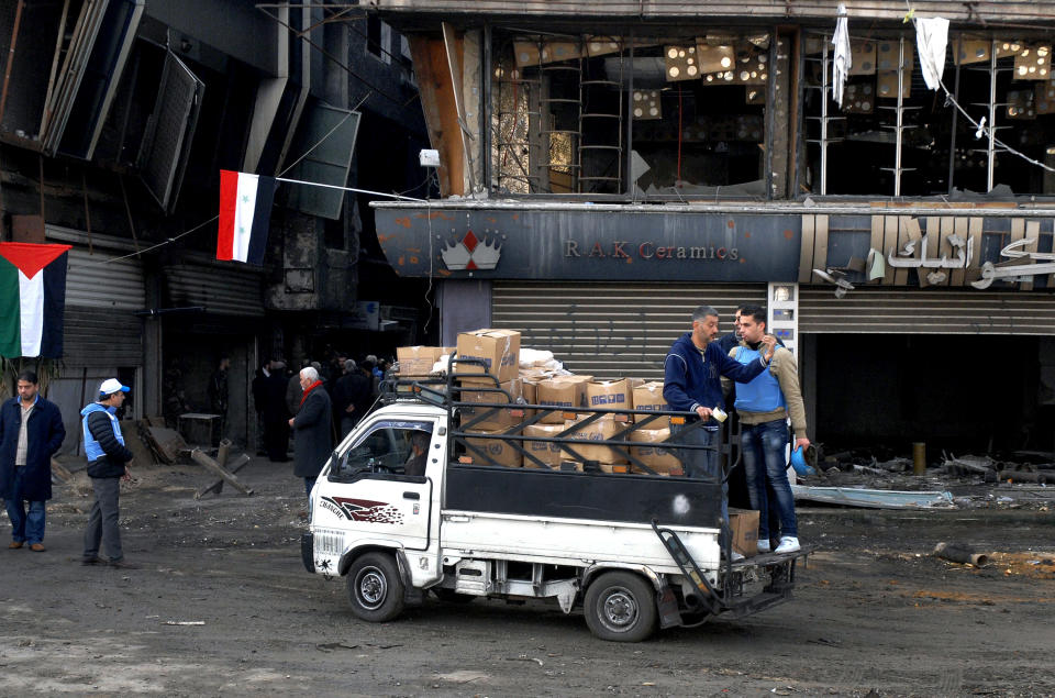 In this photo released by the Syrian official news agency SANA, a truck carries U.N. supplies at the besieged refugee camp of Yarmouk on the southern edge of the Syrian capital of Damascus, Syria, Thursday, Jan. 30, 2014. The U.N. says 600 food parcels were distributed in the camp where activists say at least 85 people have died as a result of lack of food and medicine since mid-2013. (AP Photo/SANA)