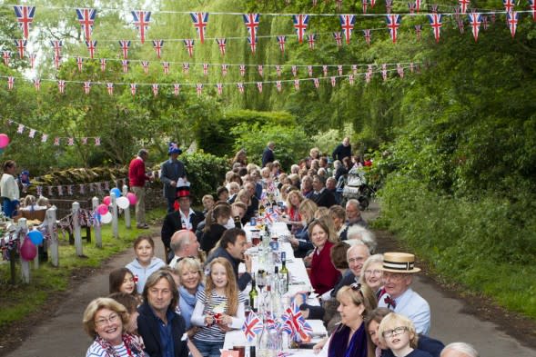 People celebrating the Queen's reign with a party.