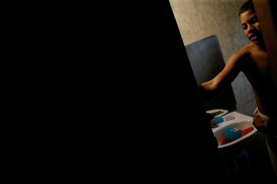 Baseball little league player Adrian Salcedo, 13, takes a bath at his home in Maracaibo, Venezuela.  (Photo: Manaure Quintero/Reuters)