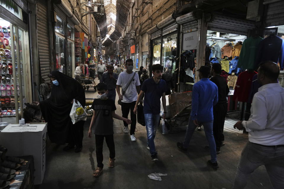 People conduct their business in the old main bazaar of Tehran, Iran, Saturday, Oct. 1, 2022. Thousands of Iranians have taken to the streets over the last two weeks to protest the death of Mahsa Amini, a 22-year-old woman who had been detained by the morality police in the capital of Tehran for allegedly wearing her mandatory Islamic veil too loosely. (AP Photo/Vahid Salemi)