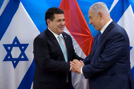 Paraguayan President Horacio Cartes shakes hands with Israeli Prime Minister Benjamin Netanyahu during a meeting at the Prime Minister's office in Jerusalem, following the dedication ceremony of the embassy of Paraguay in Jerusalem, May 21, 2018. Sebastian Scheiner/Pool via Reuters