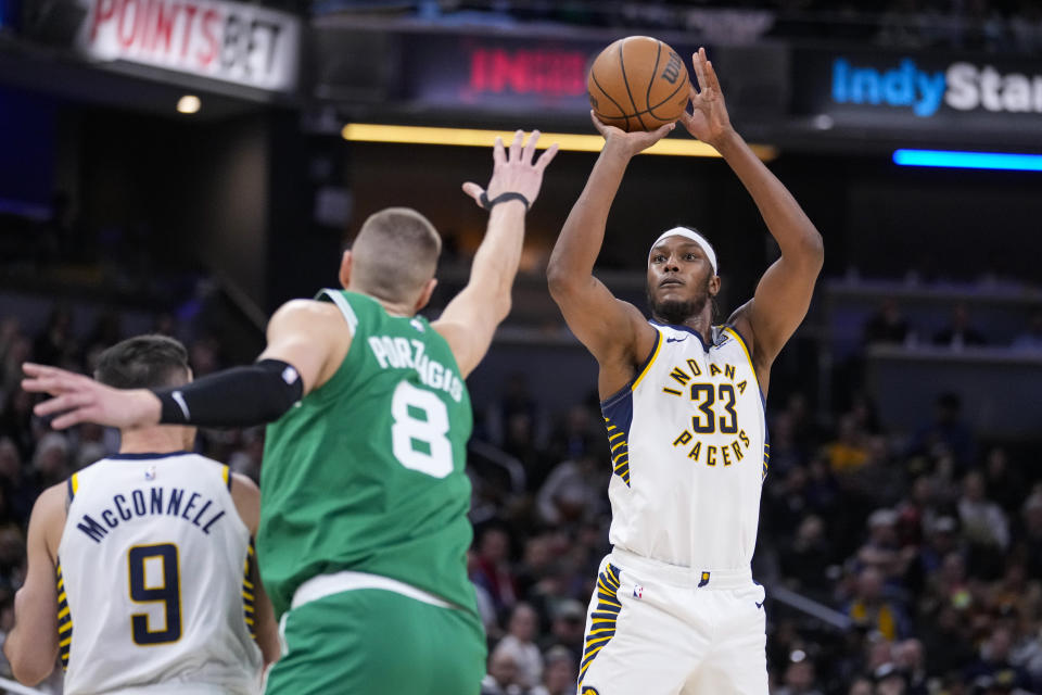 Indiana Pacers center Myles Turner (33) shoots over Boston Celtics center Kristaps Porzingis (8) during the first half of an NBA basketball game in Indianapolis, Monday, Jan. 8, 2024. (AP Photo/Michael Conroy)