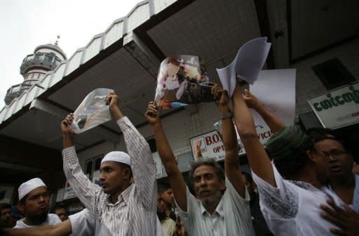 Myanmar Muslims hold up pictures of recent violence in Rakhine state during a gathering in Yangon on June 5. Myanmar's reformist government has launched an official probe into a flare-up of sectarian violence in the west of the country, state media said, pledging to punish those responsible