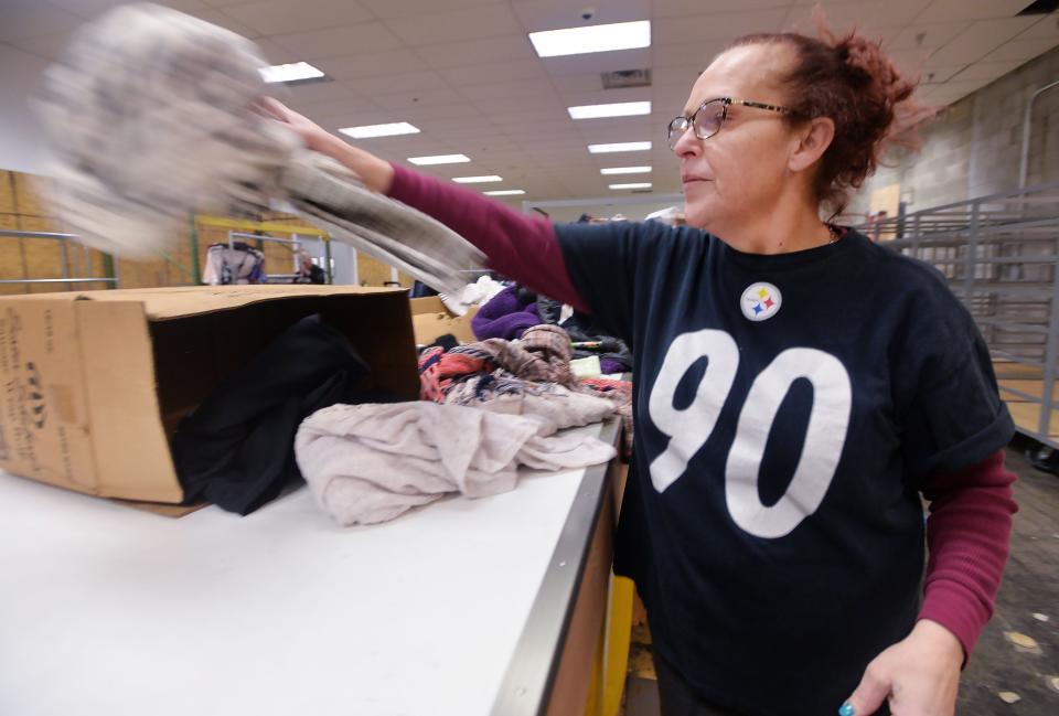 Margie Hernandez sorts clothes at the AMVETS Thrift Store in the Liberty Center.