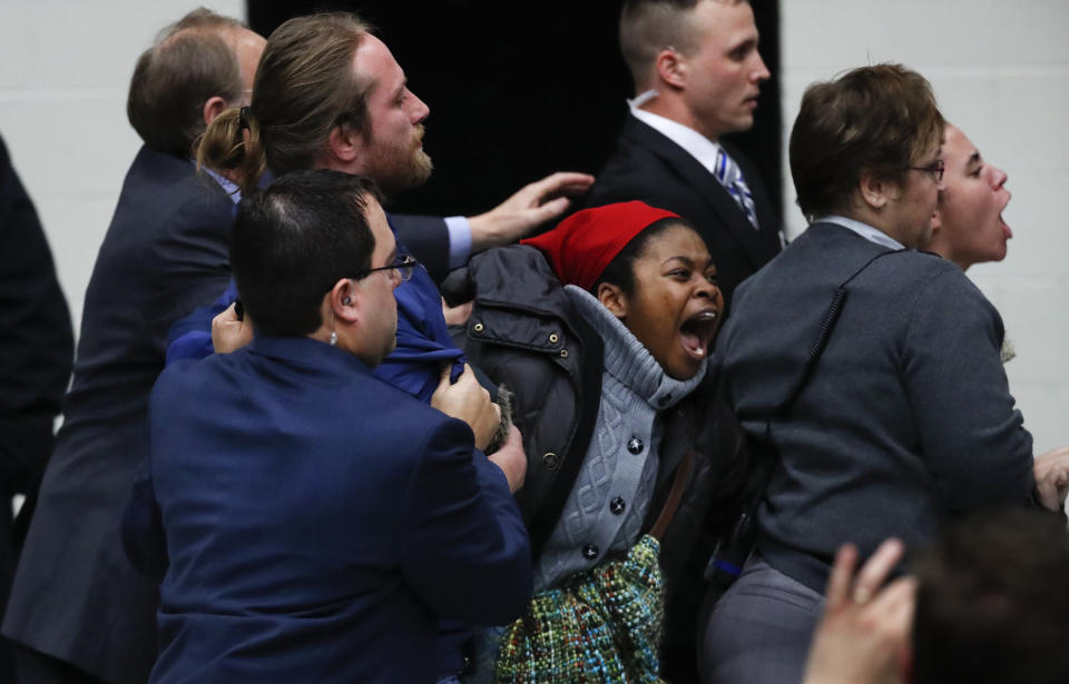 Protesters are removed from a rally for President-elect Donald Trump in Grand Rapids, Mich., Friday, Dec. 9, 2016. (AP Photo/Paul Sancya)