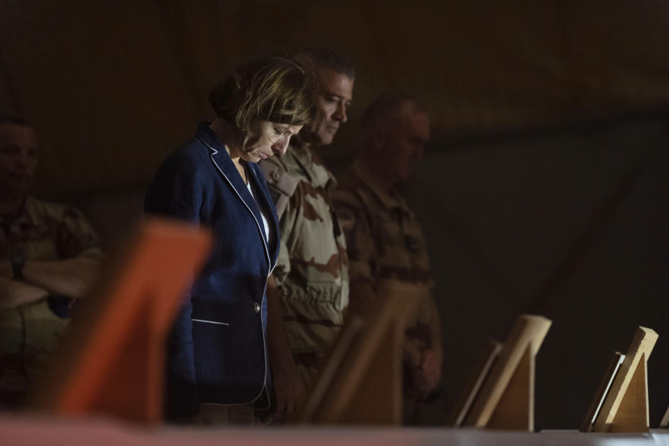 In this Wednesday Nov. 27, 2019, photo provided by French Defense Communication and Audiovisual Department (ECPAD), French Defense Minister Florence Parly, left, pays her respects to the 13 French soldiers in Gao, Mali. Parly arrived in northern Mali on Wednesday after a helicopter collision killed 13 French soldiers fighting Islamic State group-linked extremists, while some in the West African country debated France’s military presence. (Thomas Peudeleux/ECPAD via AP)