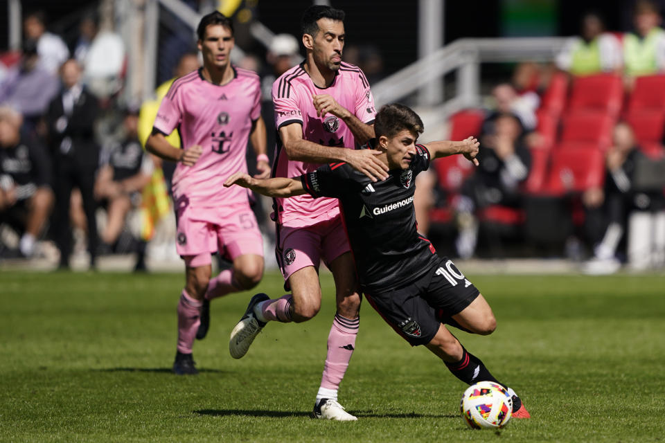 DC United midfielder Gabriel Pirani, right, shields the ball from Inter Miami central midfielder Sergio Busquets during the first half of an MLS soccer match at Audi Field, Saturday, March 16, 2024, in Washington. (AP Photo/Nathan Howard)