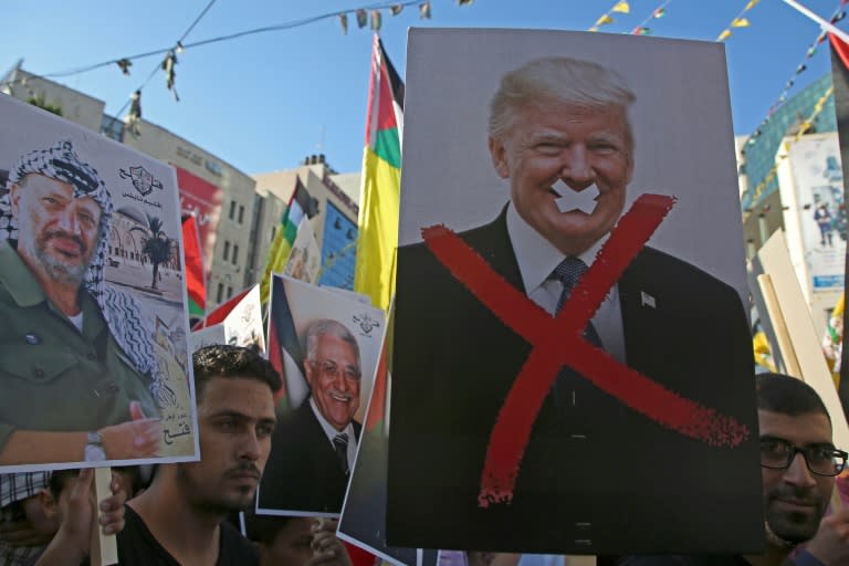 Palestinian protestors hold portraits of late Palestinian leader Yasser Arafat and US President Donald Trump during a rally in support to the Fatah movement in the West Bank city of Nablus